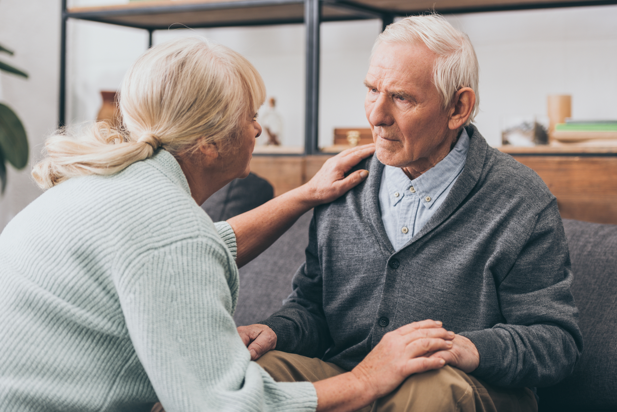 Woman consoling a confused man with Alzheimer's disease