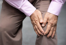 An older man grasping his knee in pain