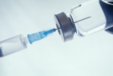 Closeup of a doctor filling a syringe with vaccines. Mandatory vaccinations are currently a debated topic with anti-vaxxers thinking they cause autism. Leading to outbreaks of preventable diseases.