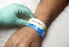 Nurse checks hospital patient fall risk bracelet.