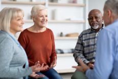 Group of three diverse people in their sixties talking to a licensed therapist.